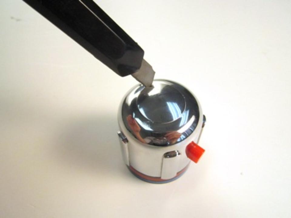 Remove the handle cap. To do so, use a flat head screwdriver to pop out the handle cap.