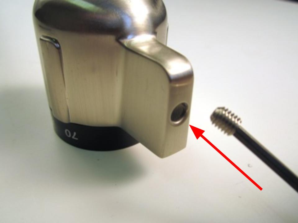 If you are installing a new handle, install the set screw on the new handle. To do so, place the set screw on the tip of the hex wrench. Use the hex wrench to install the set screw on the new handle.