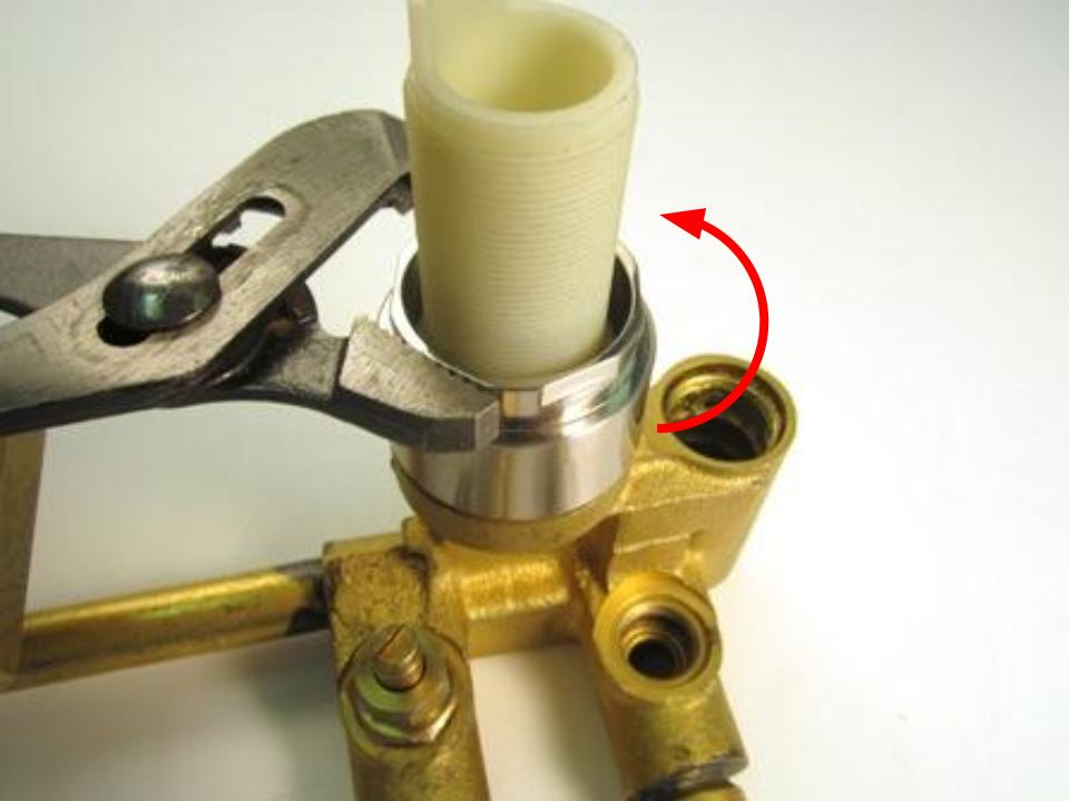 The threaded shank of the cartridge assembly is held to the valve by the he trim ring/locking nut.  This piece has flat sides to accommodate a wrench.  Twist counter clockwise to remove.  